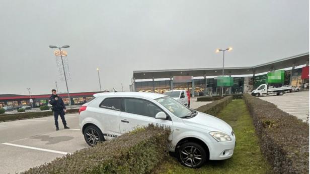 Ein Auto steckt nach Unfall in einer Hecke