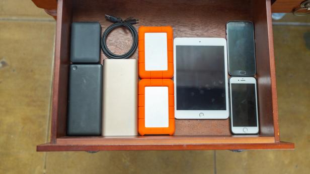 Alte elektronische Geräte in einer Schublade, u.a. Smartphones, Tablet, Powerbank.