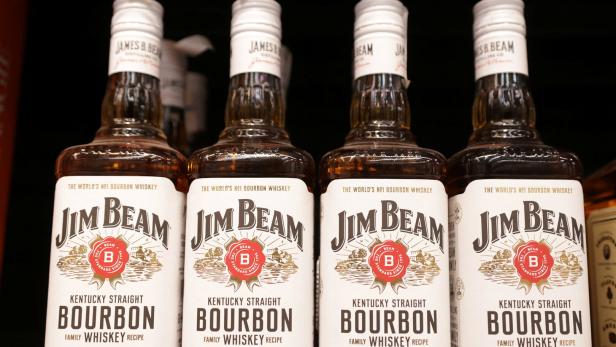 Bottles of Jim Beam are displayed on a shelf in a supermarket