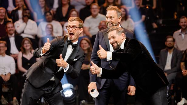 Joko und Klaas halten im TV-Studio begeistert jeweils beide Daumen hoch