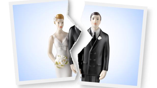 Divorce. Torn photograph of wedding cake topper.
