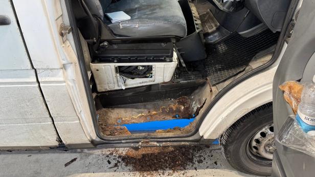 Der Einstieg eines Transporters ist stark verrostet, der Innenraum wirkt abgenutzt und es liegen Müll und Becher herum.
