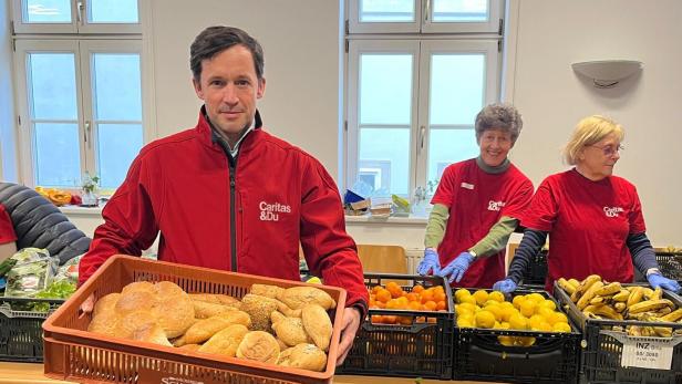 Klaus Schwertner hält bei der Lebensmittelausgabe eine Box mit Broten.
