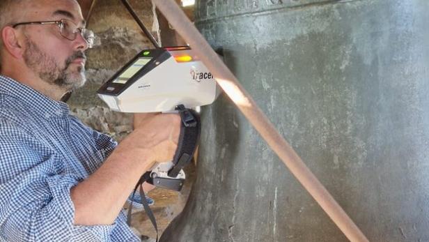 Mathias Mehofer mit dem  Röntgenfluoreszenzgerät an der Friedensglocke.