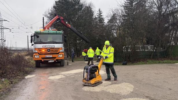 Schlaglöcher auf einer Straße werden bei Bauarbeiten gefüllt
