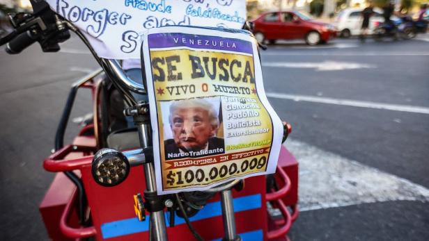 Auf einem roten Fahrrad ist ein "Gesucht"-Plakat mit Donald Trump und einer Belohnung von 100.000.000 Dollar befestigt.