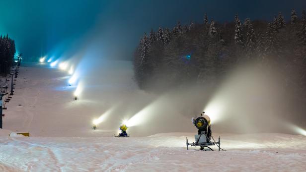 snow cannons working at night in the mountains