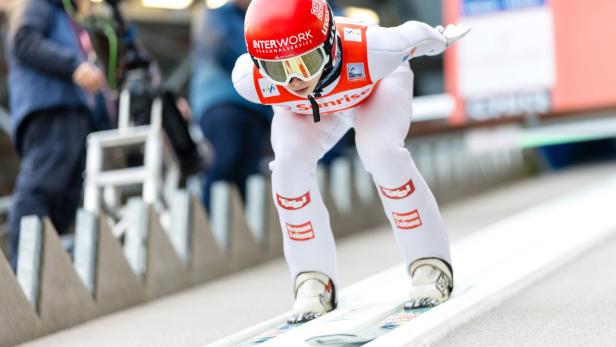 Skispringerin Lisa Eder in der Hocke in der Anlaufspur.