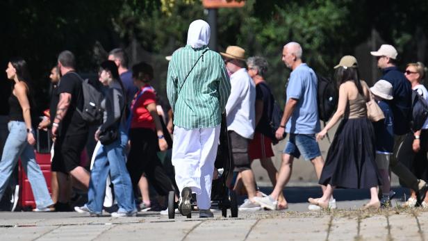 Frau in Kopftuch mit Kinderwagen