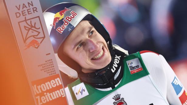 Daniel Tschofenig lehnt sich an seine Ski und freut sich offensichtlich über einen guten Sprung.