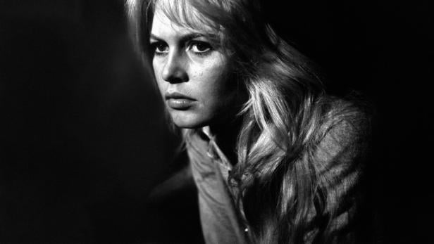 Die junge Brigitte Bardot blickt ernst in einen schwarzen Raum  