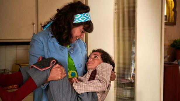 Eine Frau trägt ein Kind.