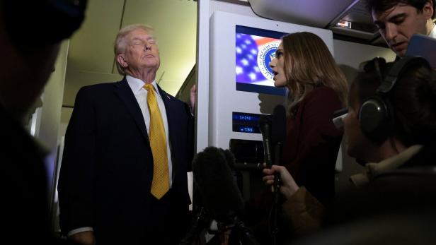 U.S. President Trump speaks to reporters aboard Air Force One en route to Joint Base Andrews