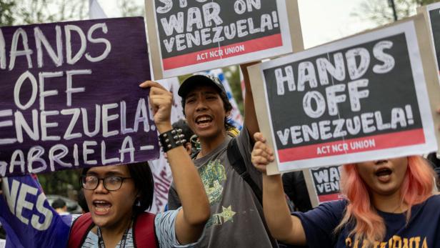 Mehrere Menschen demonstrieren mit Schildern, auf denen „Hands off Venezuela“ und „Stop the war on Venezuela“ steht.