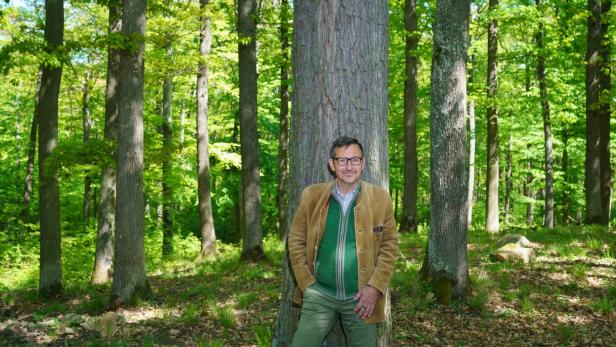 Herbert Schmid steht vor einem Baum im grünen Stiftswald.