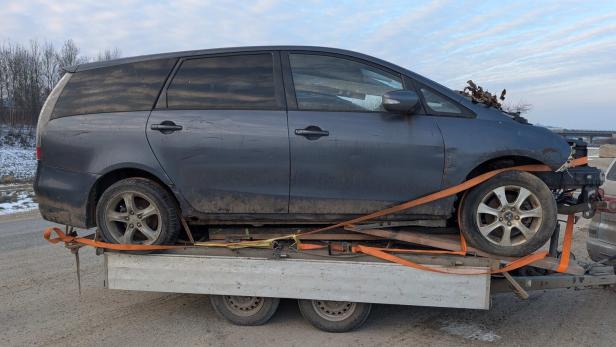 Kaputtes Auto auf einem Anhänger