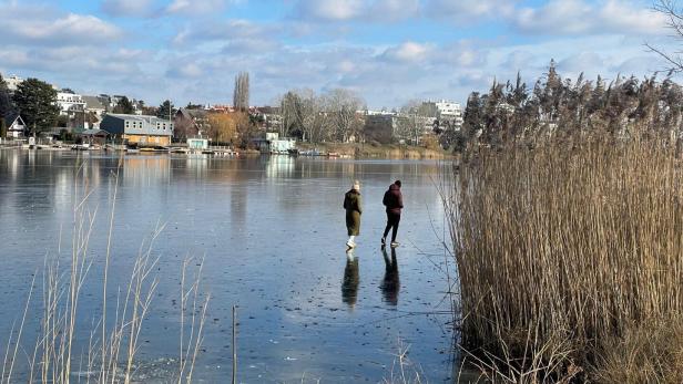 Zwei Personen gehen auf der eingefrorenen Alten Donau
