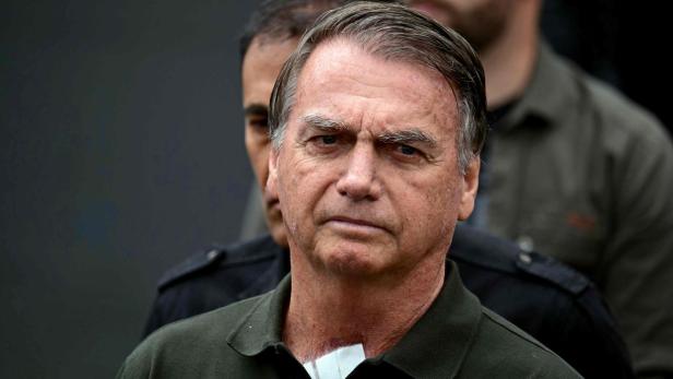 Bolsonaro mit Pflaster am Hals blickt ernst in die Kamera.
