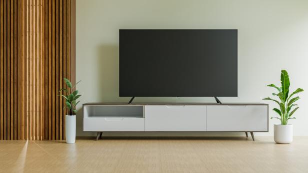 Ein Fernseher auf einem Sideboard in einem modernen Wohnzimmer.