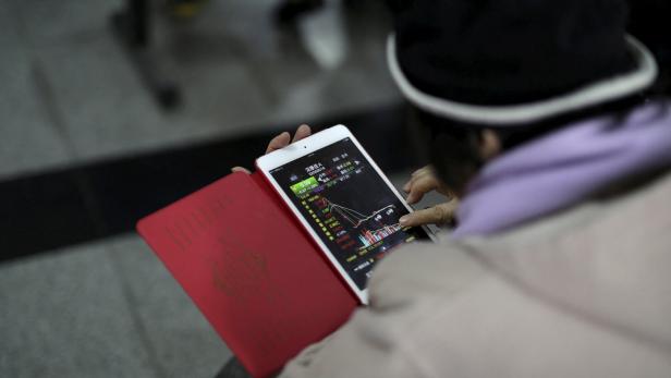 Privatinvestor checkt Börsenkurse auf einer Smartphone-App.