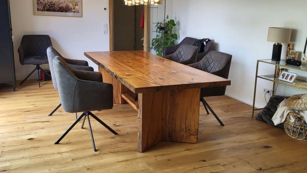 Massiver Esstisch aus Altholz mit vier gepolsterten Stühlen in modernem Esszimmer.