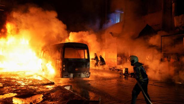 Members of the Syrian Civil Defence work to extinguish a fire that broke out following shelling