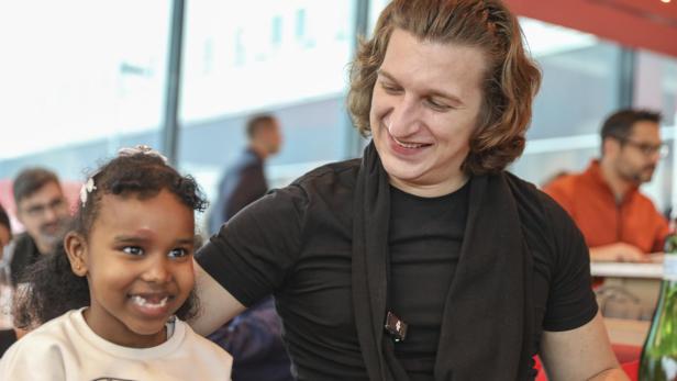 Der Influencer Satansbratan und Raxma, ein Mädchen, das das Lernhaus Wien besucht, gemeinsam am Tisch