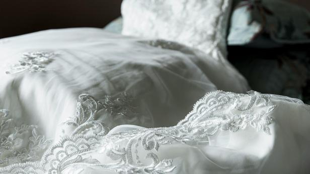 Nahaufnahme eines weißen Hochzeitskleids mit Spitze