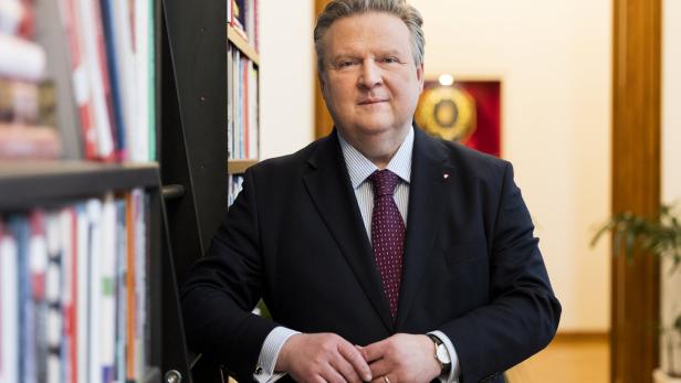 Michael Ludwig im Anzug steht vor einem Bücherregal.