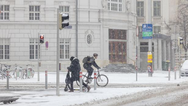 Winter in Wien: Radfahrer an einer verschneiten Kreuzung