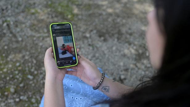 Eine Nutzerin betrachtet ein Grok-generiertes Nacktbild von  sich