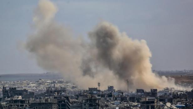 Über zerstörten Häusern in Gaza steigt dichter Rauch auf.