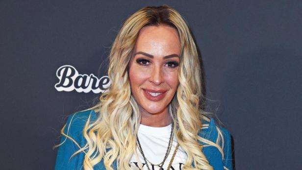 Cora Schumacher mit weißem T-Shirt und blauen Anzug auf einem Event