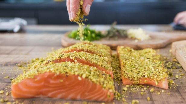 Lachsfilets werden gewürzt.