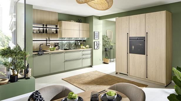 Moderne Küche in Pastellgrün und Holz mit offenen Regalen und eleganten Details.