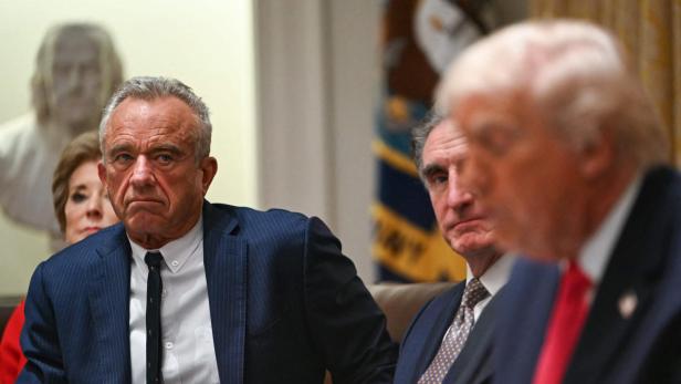 Mehrere Personen, darunter Donald Trump, sitzen an einem Tisch während einer Besprechung.