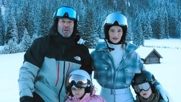 Eine Familie in Skianzügen im Schnee