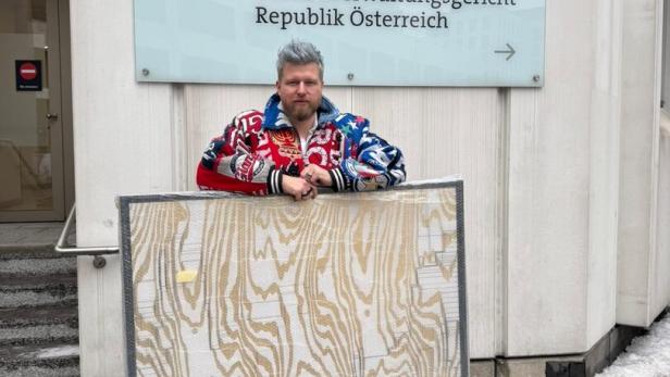 Camillo Stepanek mit einem Kunstwerk vor dem Bundesverwaltungsgericht.