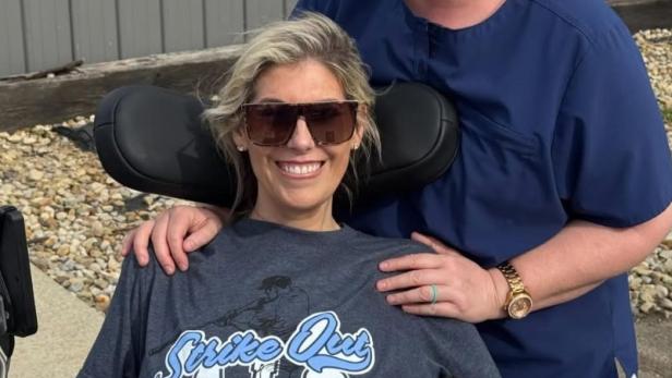 Influencerin Sara Bennett posiert lachend im Rollstuhl für ein Foto