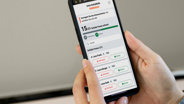 Person hält Smartphone mit geöffneter Untis-Notfallhilfe-App zur Schülererfassung.