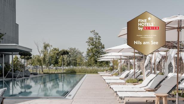 Sonnige Poollandschaft mit weißen Liegen und Sonnenschirmen, umgeben von Bäumen und moderner Architektur.