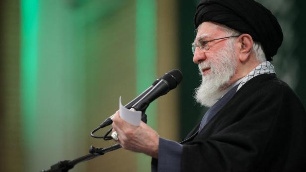 Ali Khamenei hält eine Rede vor Mikrofonen, ein Blatt Papier in der Hand.