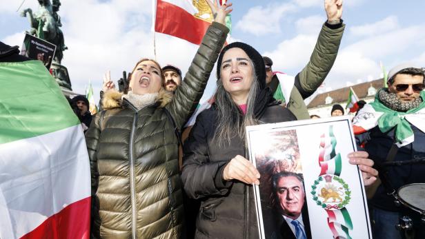 Demonstranten zeigen bei einer Kundgebung iranische Flaggen und ein Porträt von King Reza II.