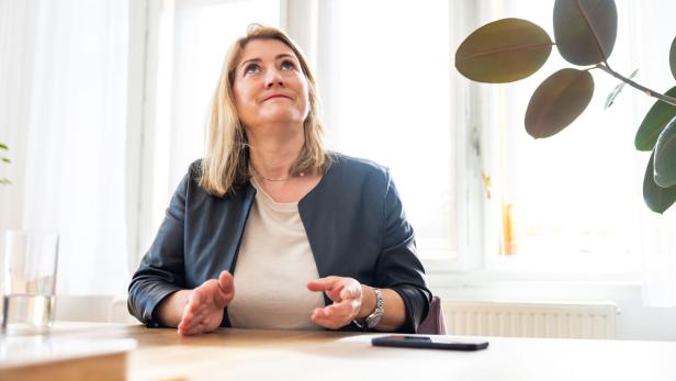 Bettina Emmerling von den Neos sitzt in ihrem. Büro an einem Schreibtisch.