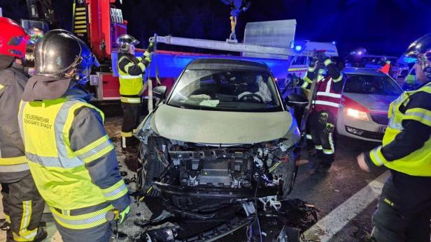 Mehrere Einsatzkräfte vor einem Unfallfahrzeug mit Totalschaden.