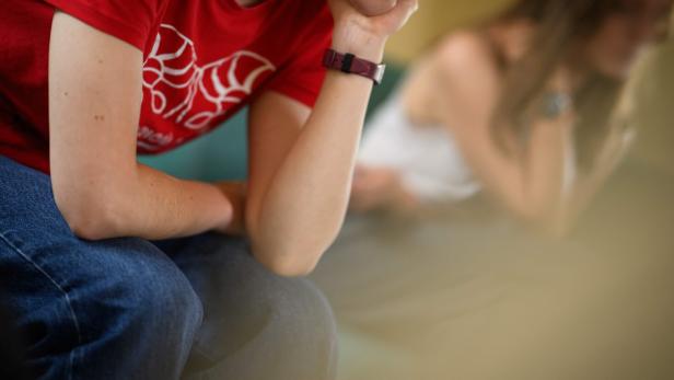 Jugendliche stützen den Kopf auf den Arm.