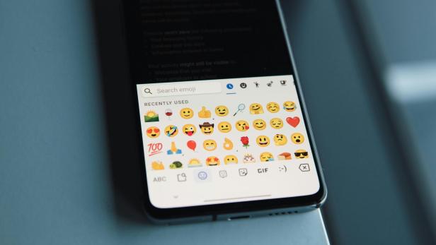 Android-Handy mit verschiedenen Emojis auf dem Bildschirm