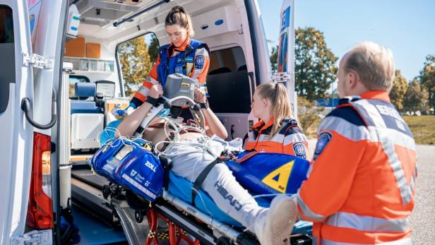 Sanitäter laden einen Patienten in einen Krankenwagen.