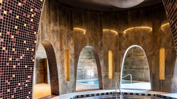 Modern gestalteter Spa-Bereich mit mehreren Thermalbecken und stilvoller Beleuchtung.