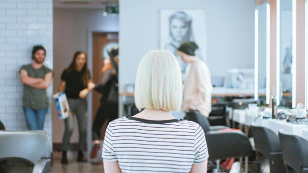 Blonde Frau mit Bob-Frisur sitzt beim Friseur